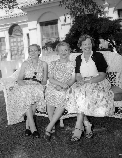 Three club presidents sitting outdoors at Maple Bluff Country Club during the women's inter-club golf match. Left to right are: Eleanor Persons of Maple Bluff, Lydia Shafer of Blackhawk, and Lucille Mell of Nakoma.