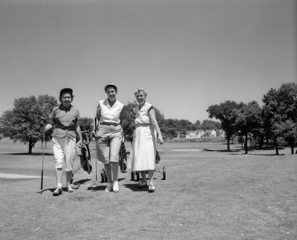 Three golfers at the Maple Bluff Country Club during the women's inter-club golf match. Left to right are Betty Heath of Maple Bluff, Helene McAndrews of Blackhawk, and Anna Hilsenhoff of Nakoma.