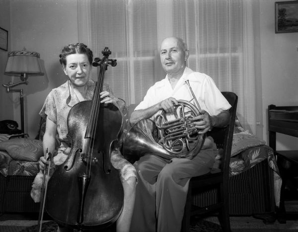 Sam Liberace and his wife, Zona, with their French horn and cello in their home at 2638 East Dayton Street. Sam and his former wife, Frances, are the parents of two well-known musicians: George, who plays the violin and conducts, and Walter, a popular concert pianist and television star. Sam played with various theater bands in Milwaukee and taught music at the high school in Marshall, Wisconsin. He moved to Madison in 1951. Zona played in the Madison civic symphony and is a supervisor in the Ceramic Arts Studio in Madison. They moved to California in 1956.
