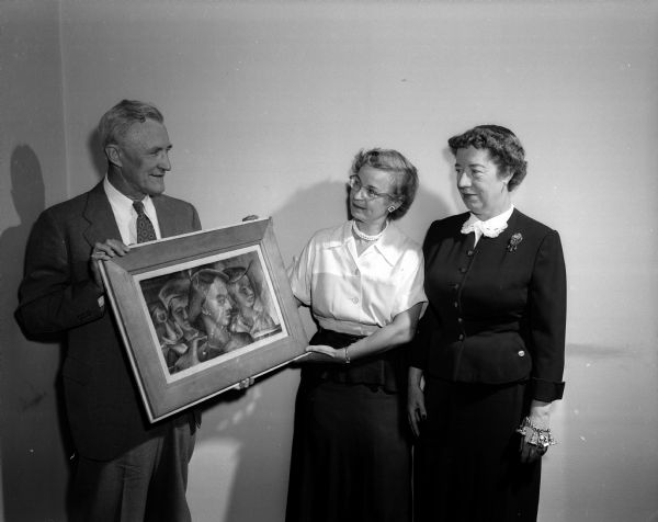 Portrait of supporters of the recently incorporated Madison Art Foundation. Philip Falk (left), superintendent of Madison schools, shows a piece of artwork to Ruth Allcott (center), director of art for Madison Schools and Dorothy Frautschi, Madison Art Foundation director.