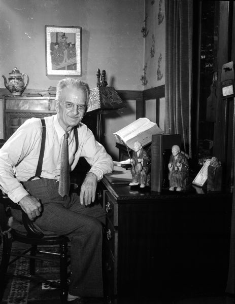 C.V. Hibbard seated at his desk in his home in Shorewood.