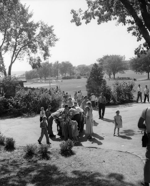A crowd lining up at a drinking fountain (bubbler) in Vilas Park.