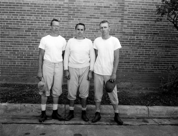 Group portrait of West High School football coaches Don Page, Fred Jacoby, and Burt Hable.