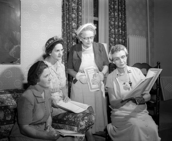 Three members of the Madison Council of Church Women executive board examine brochures with Jessie Kriel, the Americanism chairman of the Madison Woman's Club. The brochures explain the General Federation of Women's Club's campaign to restore the historic Independence Hall. They are, from left: Hazel Tasker, Glennye Morgan, Laurence Butler, and Jessie Kriel.