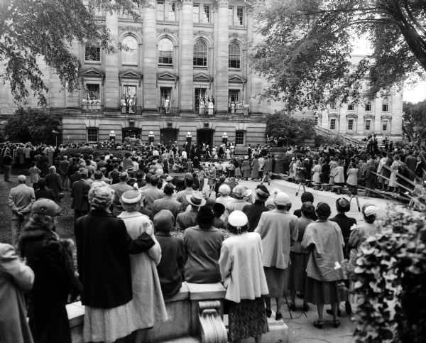 A crowd gathers on the Capitol lawn to watch the Americanization Pageant, "A Thoroughfare for Freedom," as it is portrayed on the balcony of the East wing. The ceremony, sponsored by the Madison Woman's Club in cooperation with other civic organization, was in observance of the anniversary of the signing of the U.S. Constitution.