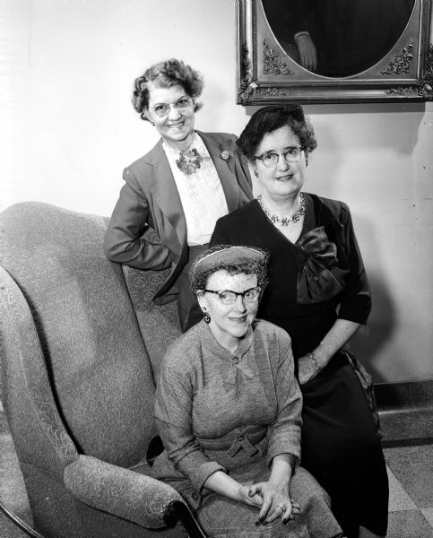 Evelyne Clauder, president of the Madison Zonta Club, sitting in a chair and surrounded by, right, Sayda Pettersen, general chairperson of the style show, and Minnie Whipple, chairperson of club finance.