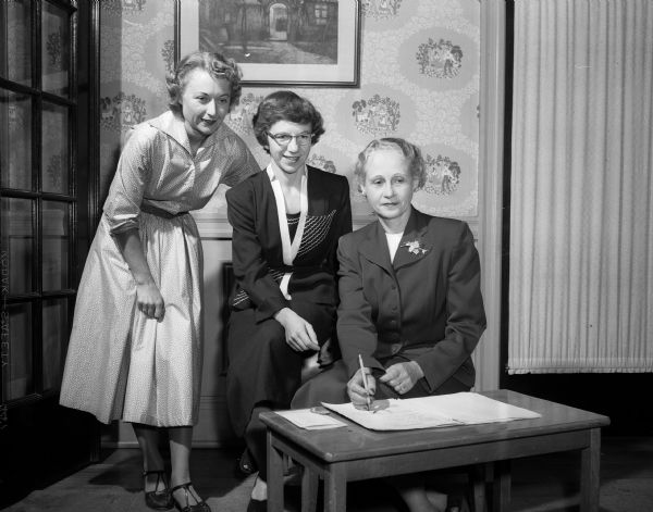 Doris Maurin, Carol Crume, and Verba Wendt look over papers while planning YWCA health education classes.