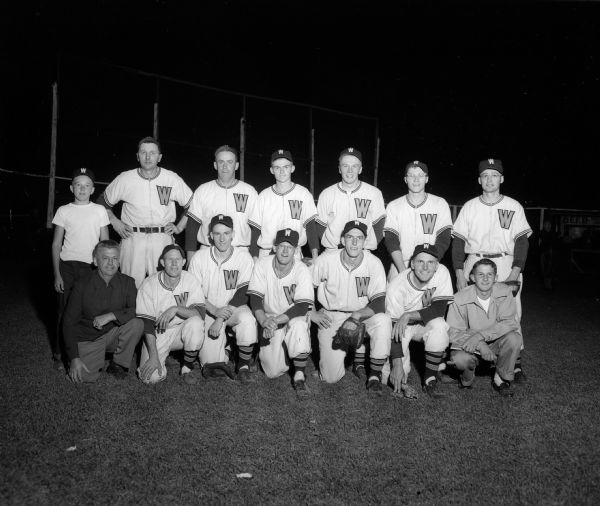 Group portrait of Wyocena's 10-man baseball squad along with the coach, business manager, batboy, and scorekeeper. The photograph was taken after the team won the 1953 Home Talent League championship.