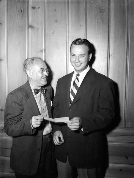 President George Holmes (right) of the Madison Junior Chamber of Commerce presents a $75 check to Bill Doudna (left) of The State Journal for the Empty Stocking Club.



