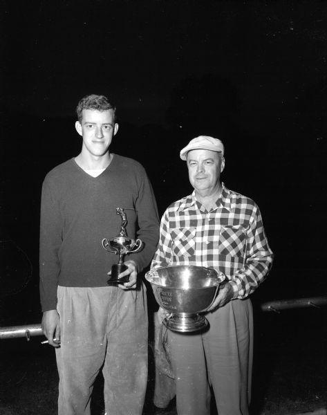 Fred Kellogg Jr. and Fred Kellogg, Sr. hold their trophies after winning the Fathers and Sons handicap golf tournament at Maple Bluff Country Club.