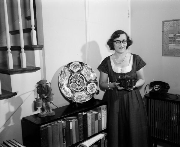 The W.H. Wikoff residence, 34C University Houses, contains many Japanese furnishings. Mrs. Catherine (William H.) Wikoff is shown with a Japanese dish and a lavishly decorated plate called an Imari plate.