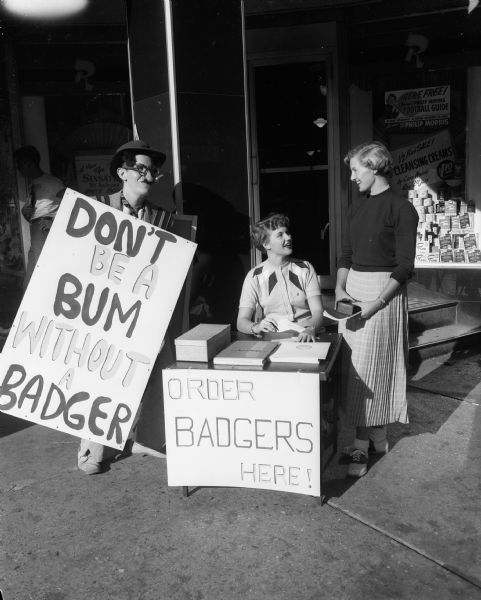Dressed as Groucho Marx, Al Gay and Karen Christoffersen sell Badger yearbooks during student orientation at the University of Wisconsin. At right is freshman Lee McGann of Shorewood Hills.