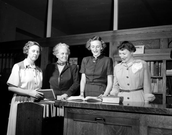 Margaret Moss, director of school libraries (second from left), meets with new librarians Marguerite Hasse (Lincioln & Dudgeon Schools), Joan Mundt (Schenk and Mendota Schools), and Ruth Peplinski (West High School). All school librarians officially became school staff members in September, 1952, when the Board of Education accepted the administration of school libraries from the Madison Public Library Board after 42 years.