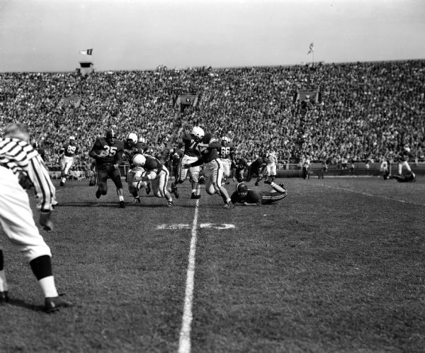 Alan (The Horse) Ameche (#35) is stopped by Penn State defenders Sam Green, Ron Younker and Bobby Allen during the football game.