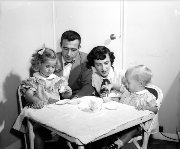 Horace A. and Jane Page attend a "tea party" with their daughters, Penny and Julie.  Jane is the chairman of the Understanding Children Group, a project of the Junior Division of the University League. The Junior Division is a support organization for U.W. faculty women and wives of faculty members.