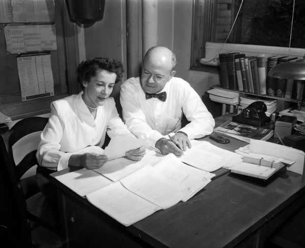 U.W. chemistry professor M. Leslie Holt and his wife Gretchan check the proofs of a new book for which he is an assistant editor. Gretchan is in charge of the handicrafts interest group of the Junior Division of the University League. The Junior Division is a support organization for U.W. faculty women and wives of faculty members.