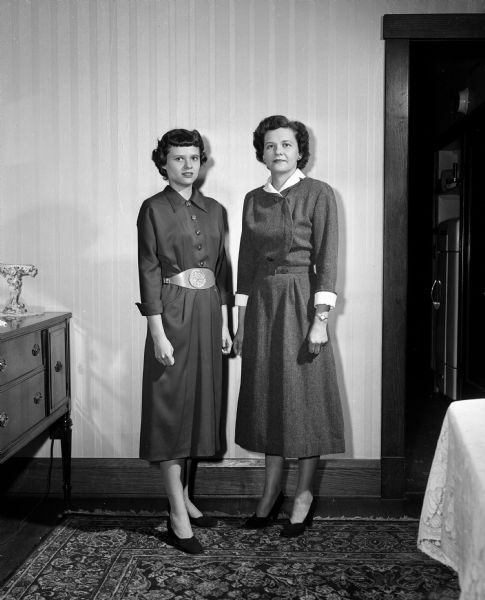 Elizabeth (Mrs. Howard C.) Miller and her daughter Ethel model dresses sewn by Elizabeth. The photograph was taken to accompany a <i>Wisconsin State Journal</i> article about Elizabeth's seamstress work for herself and her daughter.