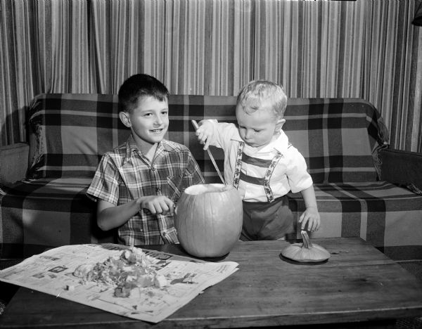 James Hall (left) and brother Terrence (right), sons of Mr. and Mrs. James Hall, work on their Halloween pumpkin. Both boys have their birthday on Halloween.