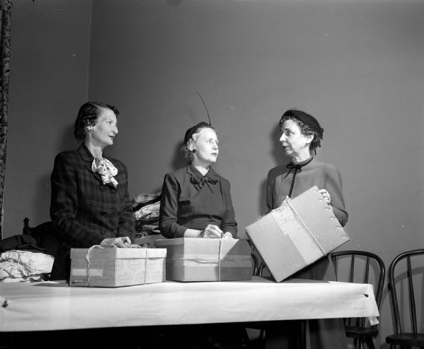 Three women of Grace Episcopal Church pack boxes of donated articles for the world's needy as part of the Madison Council of United Church Women's World Community Day. From left to right are: Maxine Hanesworth, Mrs. John Shumate and Vera Browne.