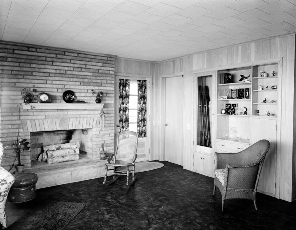 Interior view of the den and recreation room in the residence of Leo Scheberle. The room features a fireplace, wood paneling, and shag carpeting.