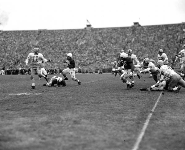 Alan Ameche, nicknamed "The Horse," carries the ball during a University of Wisconsin vs. Iowa football game.