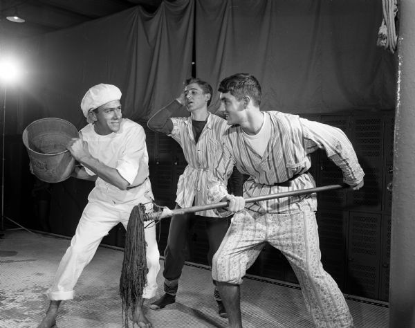 During a scene from the University of Wisconsin Men's Dolphin Club show "Robin Hood Comes Clean," Nick Woodas of Madison portrays the king in anguish over the antics of two subjects in the throne room. They are portrayed by Kenneth Opgenorth of Kewaskum, left and Bunny Restuccia of Boston.