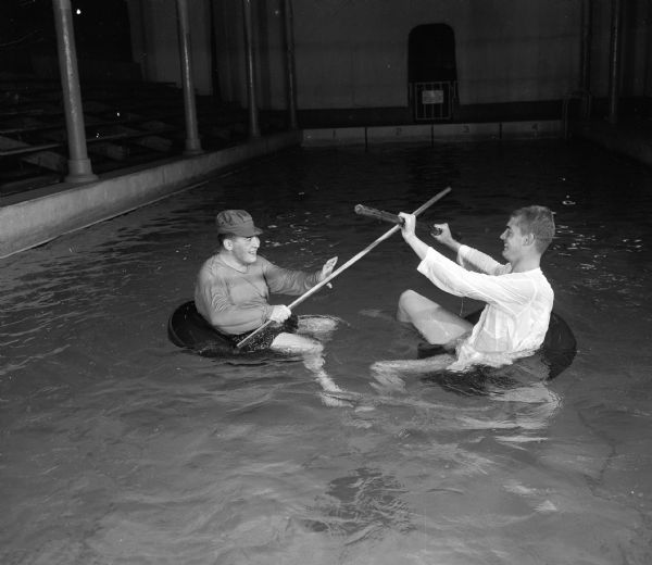 During a scene from the University of Wisconsin Men's Dolphin Club show "Robin Hood Comes Clean", Felix Pulgram of Milwaukee (as Robin Hood) and Robert Becker, Wauwatosa, (as Friar Tuck) joust in the water.