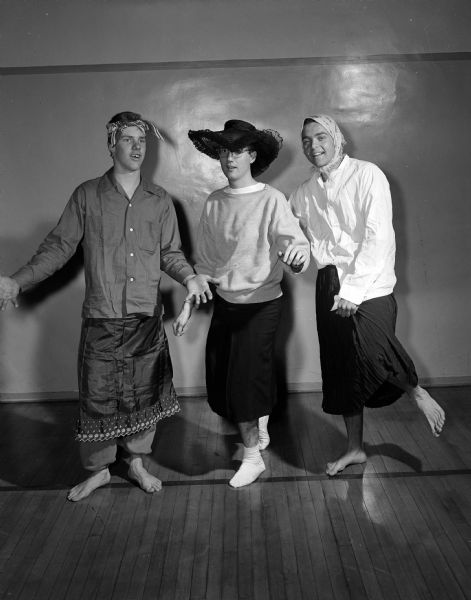 Don Aitken, Bill Colletti, and David Vilas dressed as women as they practice their cheerleading act for the "Teen Time" television program. "Teen Time" was a skit and general interest show put on by teens from the five Madison high schools. It was broadcast live for a half hour every Saturday afternoon at 3 o'clock on WMTV. The first show broadcast on Nov. 21, 1953.