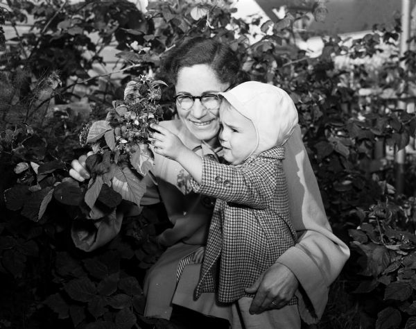 Myra Swingle and her two-year-old son, Lanny, picking raspberries together at their home at 2637 Hoard Street.