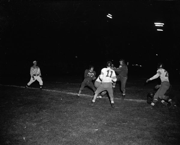 Jim Steel, a Kenosha player, makes a touchdown during a Central High School vs. Kenosha High School football game. Also pictured are Ed Hart (#33) of Kenosha and Don Beale of Central.