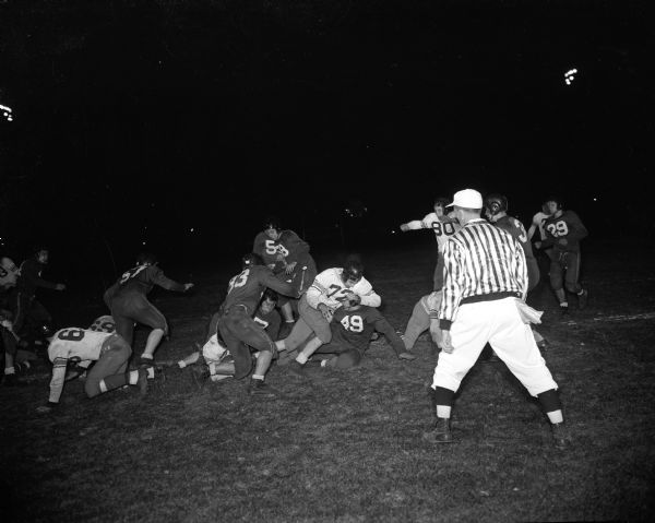 Central football players Ted Williams and Bob Gunderson and Kenosha players Ed Hart, Jack Mitchell, and Ron Holly are pictured during a game between Central High School and Kenosha High School.