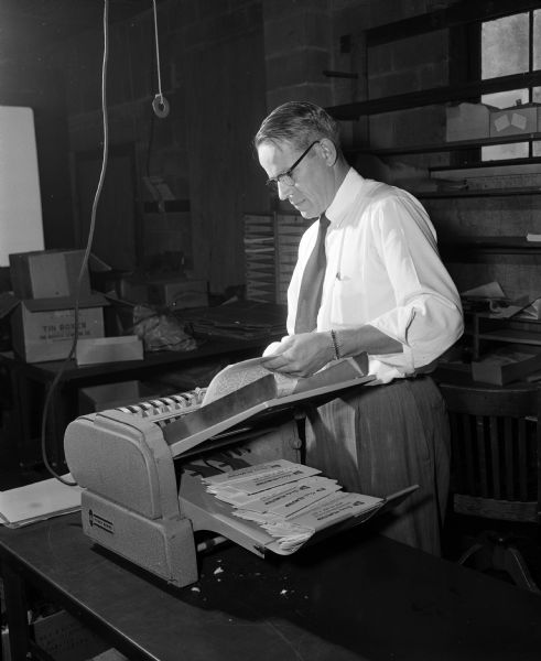 William Dewey of Visual Education Consultants, Inc. operates a folding machine that prepares manuals to accompany news and curriculum filmstrips.