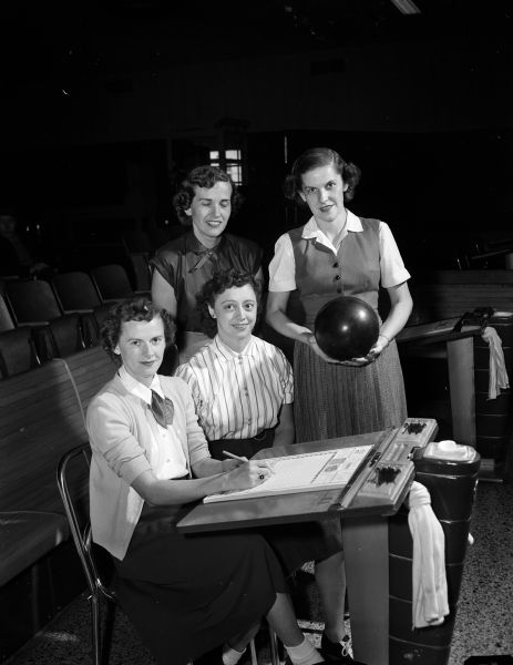 Group portrait of the officers of Madison Women's Municipal Bowling League. The league bowls at the Bowl-A-Vard Lanes. From left to right are: Mrs. Pierce Nelson, president; Mrs. B. Arden Taylor, secretary; Mrs. Alvin Kleinsmith, treasurer; and Nina Richards, publicity chairman.  Mrs. James Engleberger, vice-president, is not pictured.