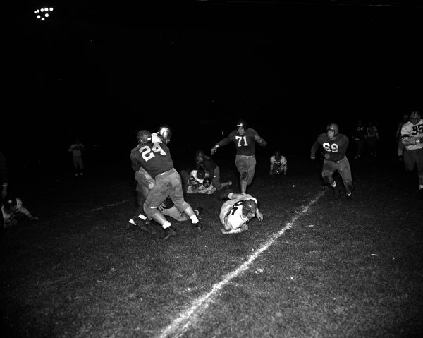 Action shot taken during the University of Wisconsin freshman intra-squad football game. Half-back Norman Smith is tackled by Woody Sorenson (#24).