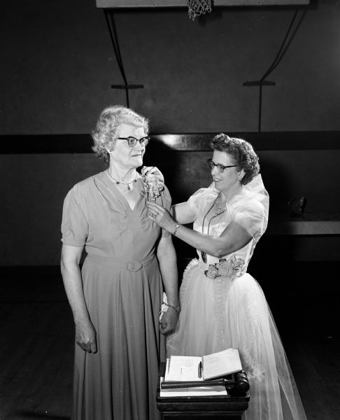 Lydia Wolfe receives a corsage from Bernice Swadley, the president of the Eagles' Auxiliary, as she is honored for organizing the Auxiliary sixteen years prior.