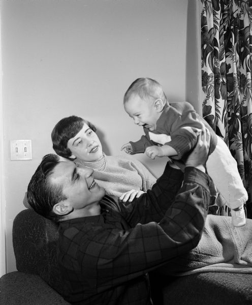 Alan Ameche, the University of Wisconsin's football full back, and nicknamed "the Horse," is pictured with his wife Yvonne and their five-month-old son Brian at their 131 Craig Avenue house.