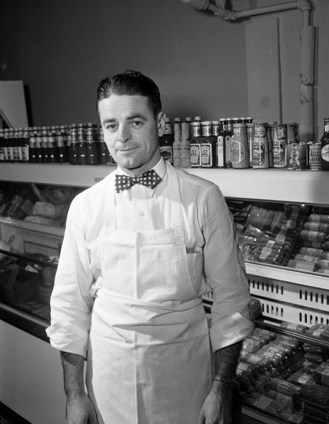Portrait of Max Waln, with bowtie, the owner and manager of Millins Supermarket, located at 553 West Main Street. The market was formerly known as Vincent Troia Supermarket.