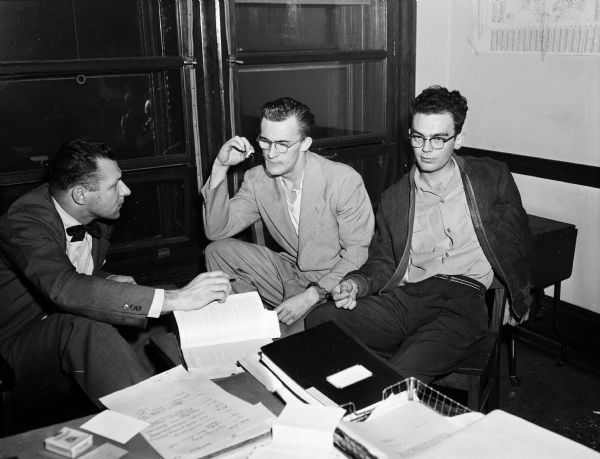 Assistant District Attorney Robert I. Perina (left) hearing the confessions of Douglas R. Wright of Baraboo and William G. Lavine of St. Louis. The two robbed the Party Port Beer Depot in Madison.