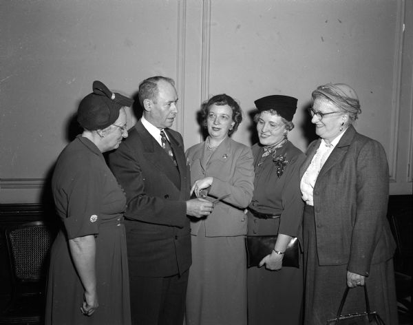 Milo K. Swanton, a member of the president's Agricultural Advisory Committee, speaks with members of the Women's Republican Club. With him, left to right, are: Mrs. Herbert (Harriett) Loucks, Mrs. W.W. (Marian) Fox, Mrs. Francis (Gertrude) Lamb, club president, and Mrs. William Jens of Milwaukee, president of the Wisconsin GOP Clubs, Inc.