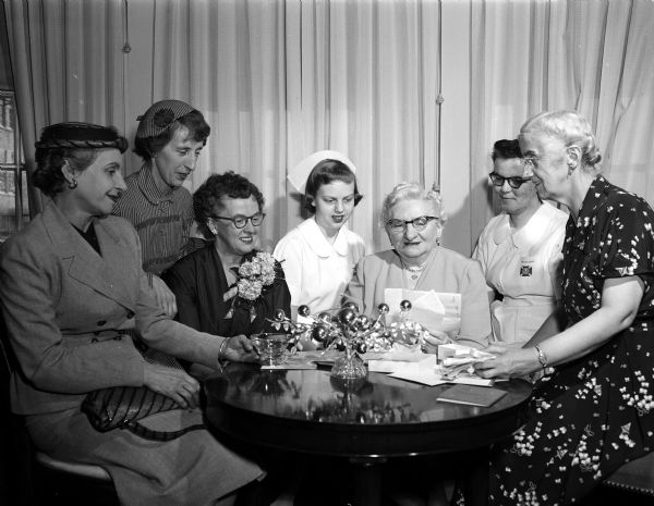Miss Nellie Brown is a guest of honor at the annual Christmas silver tea given by the Madison General Hospital Nurses' Alumnae Association. She was honored for having completed 25 years of service as night superintendent. Pictured left to right are Merle (Mrs. Adolph) Bieberstein, Ann (Mrs. R. J. ) Putnam, Miss Sadie Anderson, Miss Ann Espenes, Miss Nellie Brown, Miss Betty Ballinger, and Miss Beatrice Severson.