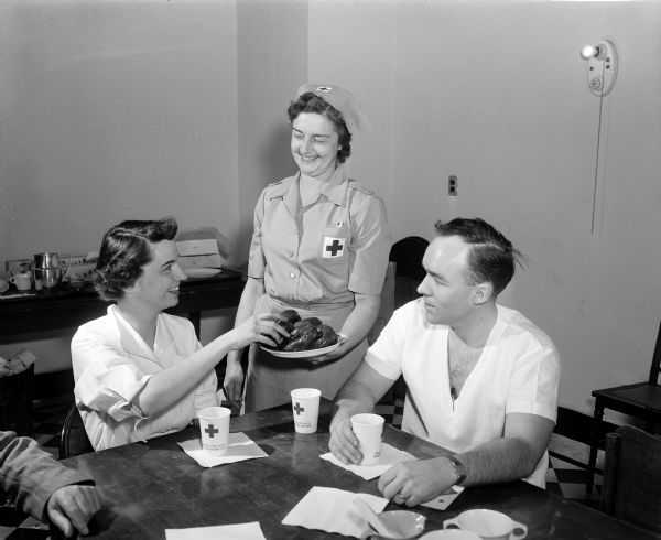 Myrna Brindley offers doughnuts to Madison General Hospital employees and staff blood donors Jane Watson and Richard Zellinski. The American Red Cross bloodmobile visited the hospital.