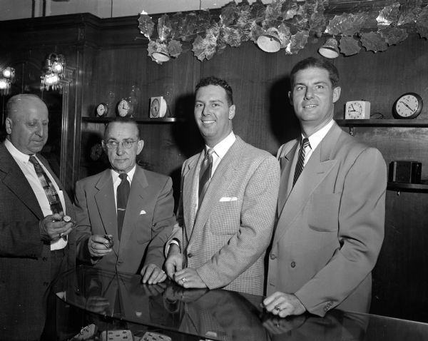 Two bowlers are given new Elgin wrist watches from the Goodman Brothers as an award for rolling the high individual single games in the Madison Bowling Association tournament. Left to right: Bowlers Nic Paltz and Leroy (Punk) Bowes, Bob and Irwin Goodman. The presentation was at Goodman's Jewelry Store, located at 220 State Street.