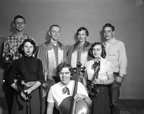 Group portrait of musicians from Madison East High School who will participate in the annual winter concert. In front with a cello is Mary Lou Daniel. Behind her are Carol Bruley (left) and Nan Rasmussen. In the back row are, left to right, Allyn Humphrey, John Spaeni, Judy Voss, and Charles Amacker.