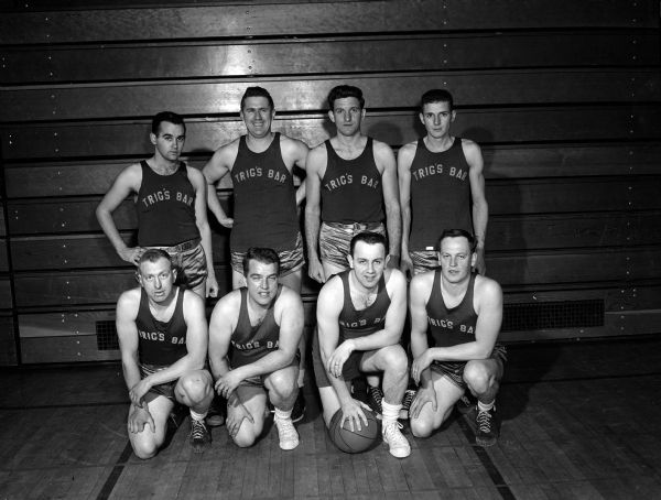 Group portrait of Trig's Bar basketball team. The team won the Wingra League championship in the Madison municipal basketball program. Standing, left to right, are: Patrick Burns, Tom Muldowney, William Neitner, and Harold McGuire. Kneeling, left to right, are William Beld, Donald Olson, John Gavin, and Manager Tony Littel.
