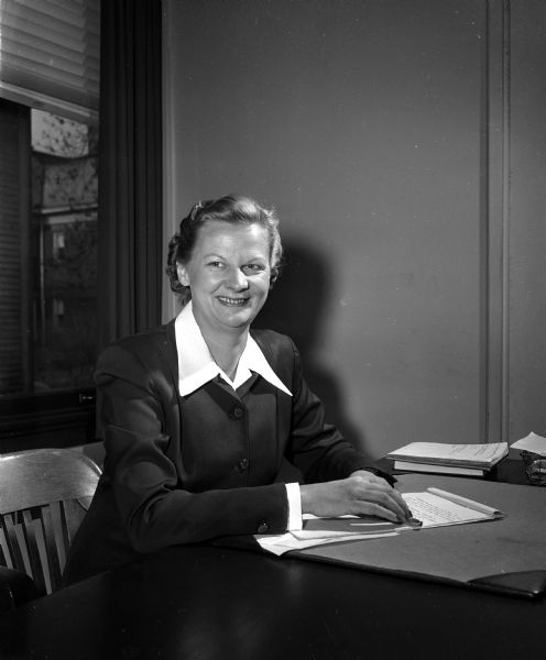 Portrait of Lillian Nitcher, Associate Director of the Community Chest of the Community Welfare Council, seated at her desk.