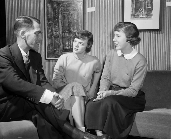 As part of Co-ed's Week, an event designed to combine features of special interest to college women, one of the speakers at the career conference is conferring with conference leaders. Left to right: H.C. Hutchins, U.W. associate professor of education; Patricia Kerbs, Webster Groves, Missouri, chairman of the speakers committee; and Emily Smith, Kenosha, general chairman of Co-eds Week. The event is sponsored by U.W. Associated Women Students organization.
