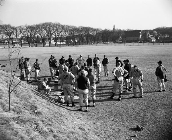 The University of Wisconsin baseball team gathers around coach Arthur Mansfield before an outdoor workout on campus.