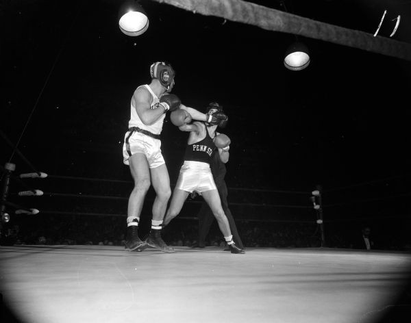 Wisconsin's Bobby Hines (left) jabs at opponent Joe Goleman of Penn State during their bout in the University of Wisconsin-Madison Field House. Hines won by a TKO and it was his tenth straight intercollegiate victory.