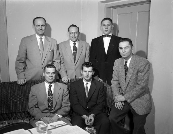 Shown left to right, first row, are: Glenn Nording, basketball coach; Leon Stolen, football captain; Otto Breitenbach, football coach. In the back row are: Wesley Burmeister, toastmaster; Donald Atkins, president of the Civics Club which sponsored the event; and Dick Ripp, who will be Middleton's basketball captain in its final league game (of 1954) against Wisconsin High in the University of Wisconsin-Madison Field House.