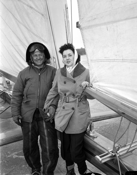 Norman and Dorothy Braith stand beside Norman's iceboat "Mary B," the prize-winning iceboat owned by O. T. Havey. Norman is one of the crewmen and Dorothy is a surviving recipient of ten pints of blood from the Red Cross during surgery.
